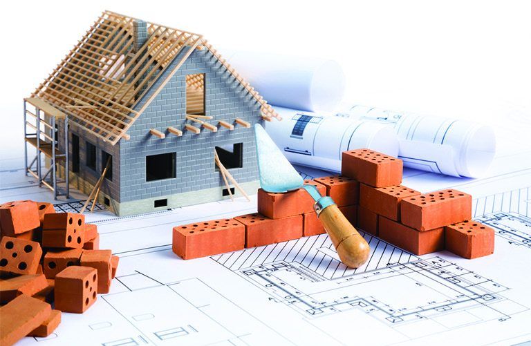 Maquette de maison en chantier sur des plans